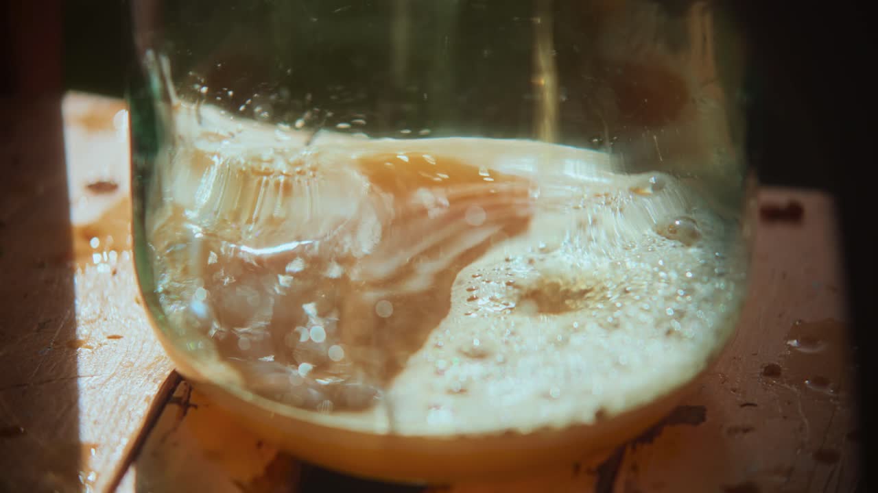 Close-up shot of fruit juice falling in a glass jar