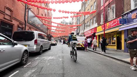 cars and pedestrians navigate vibrant chinatown street