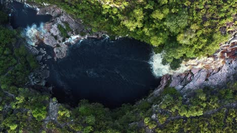 Vista-Aérea-De-Un-Dron-De-Pájaro-De-La-Impresionante-Cascada-Del-Pozo-Del-Diablo-Rodeada-De-Rocas-Y-Follaje-De-La-Jungla-En-El-Hermoso-Parque-Nacional-Chapada-Diamantina-En-El-Noreste-De-Brasil