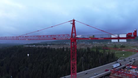 crane by busy highway bridge construction zone circling