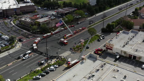 Drone-Aéreo-De-Policías-Y-Camiones-De-Bomberos-Con-Una-Enorme-Bandera-Americana