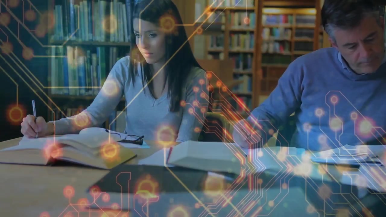 Compagni di studio che posizionano una penna attivando circuiti pulsanti mentre scrivono e annotano documenti in biblioteca.