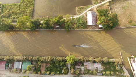 Vertikale-Drohnenaufnahme-Eines-Bootes,-Das-Auf-Dem-Fluss-Fährt