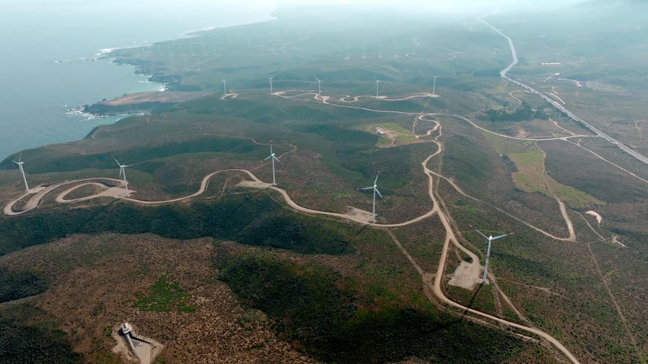 vista aérea panorámica de los aerogeneradores de un parque eólico en las áridas montañas del norte de chile
