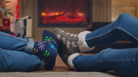 pareja usando calcetines de lana frente a la chimenea