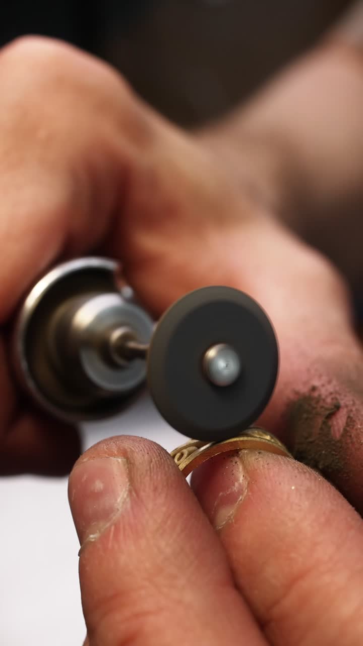 Craftsman's Hands Polishing a Gold Ring with a Rotary Tool