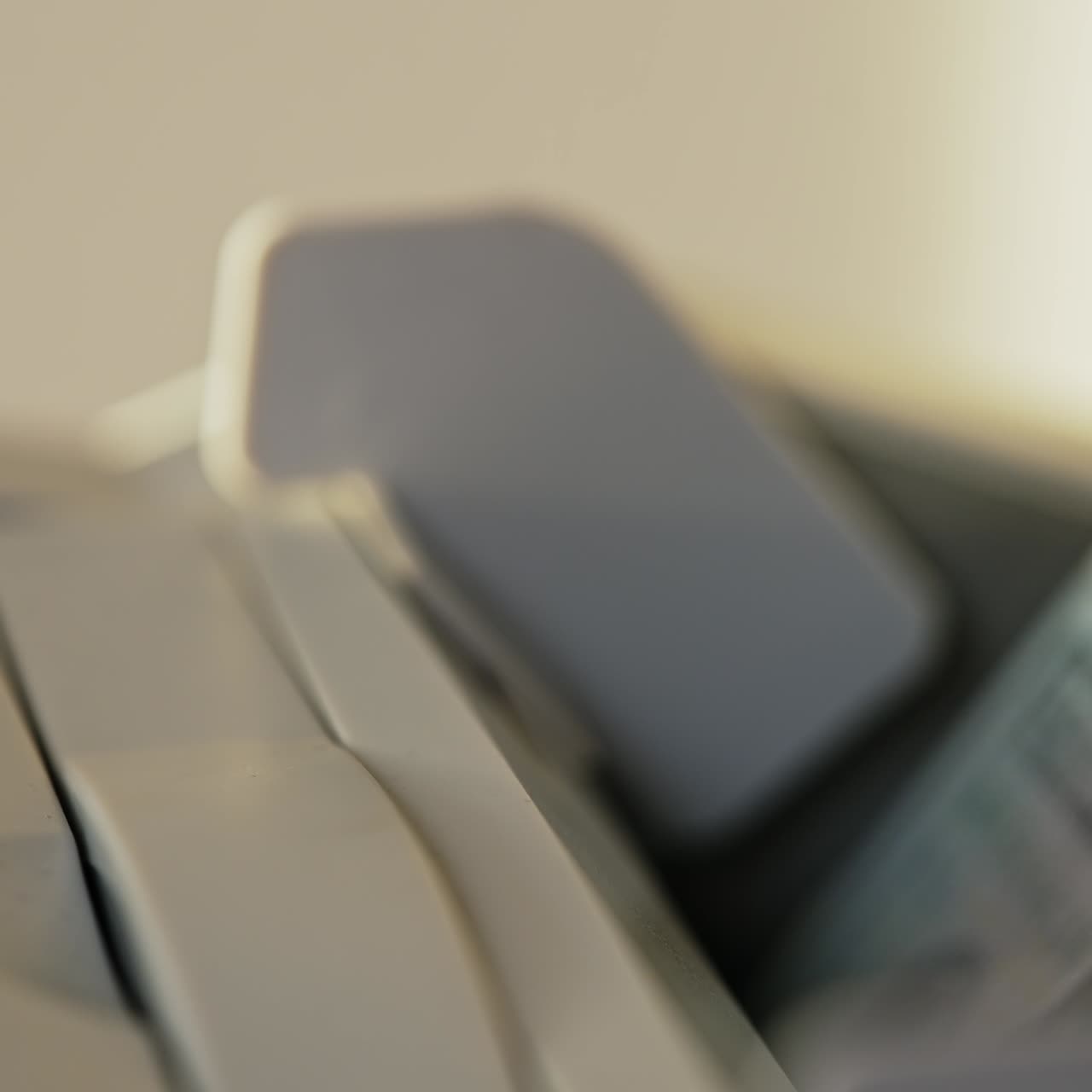 Male hand placing money into counting slot of cash machine. One hundred dollar bills quickly disappearing in the apparatus. Close up
