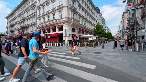 vienna, austria - june 9, 2025: tourists cross the busy street in wien. visitors stroll through a lively street in wien, enjoying the sunny day and exploring the vibrant atmosphere