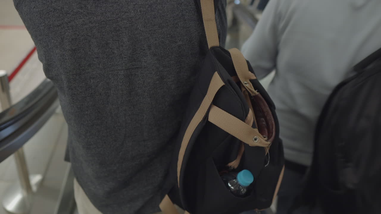 человек с рюкзаком на эскалаторе в торговом центре