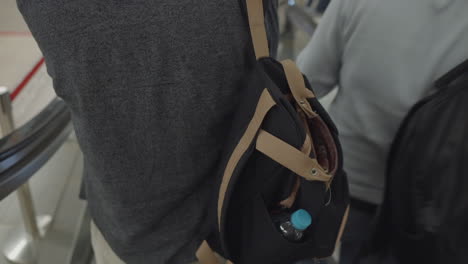 persona con mochila en la escalera mecánica en un centro comercial