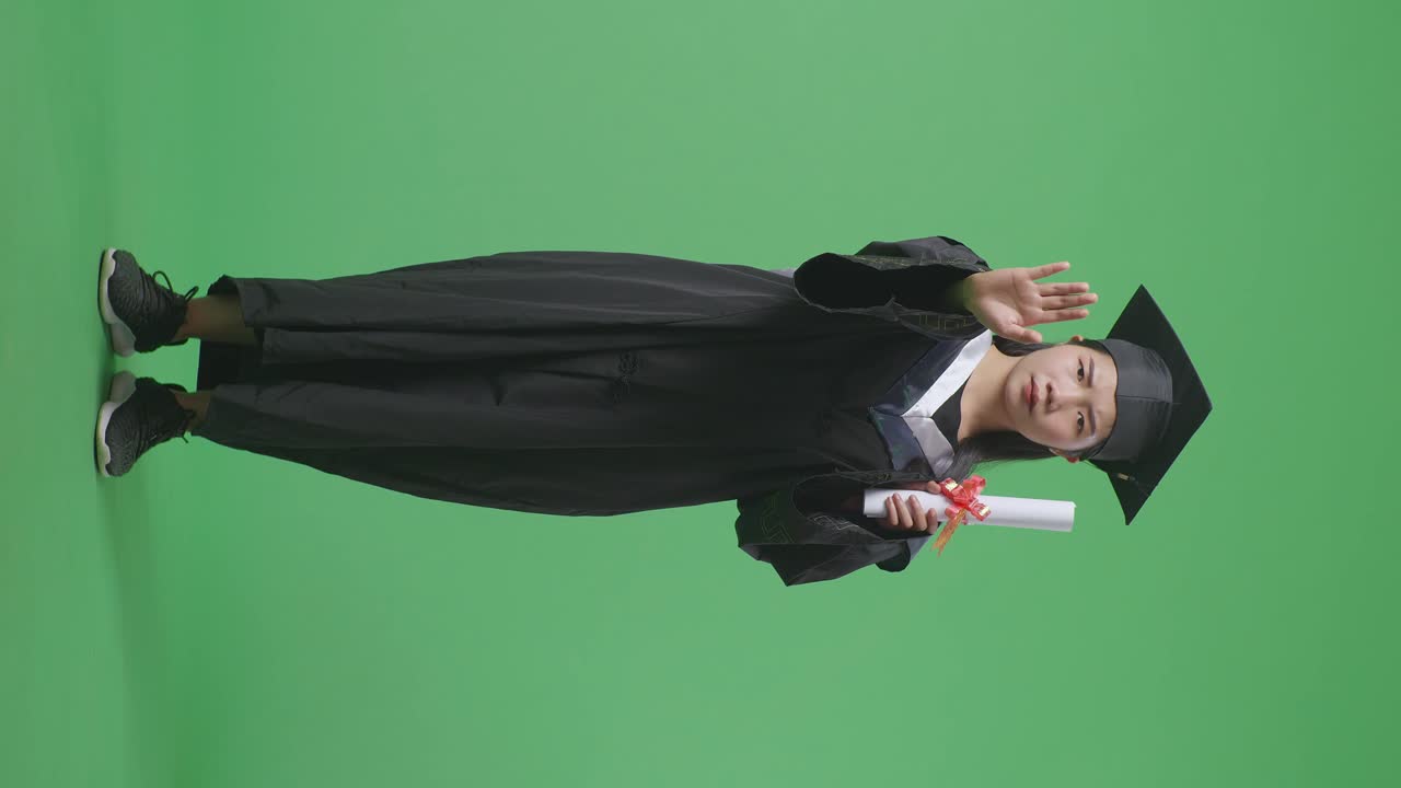 Donna laureata che tiene in mano un diploma su schermo verde