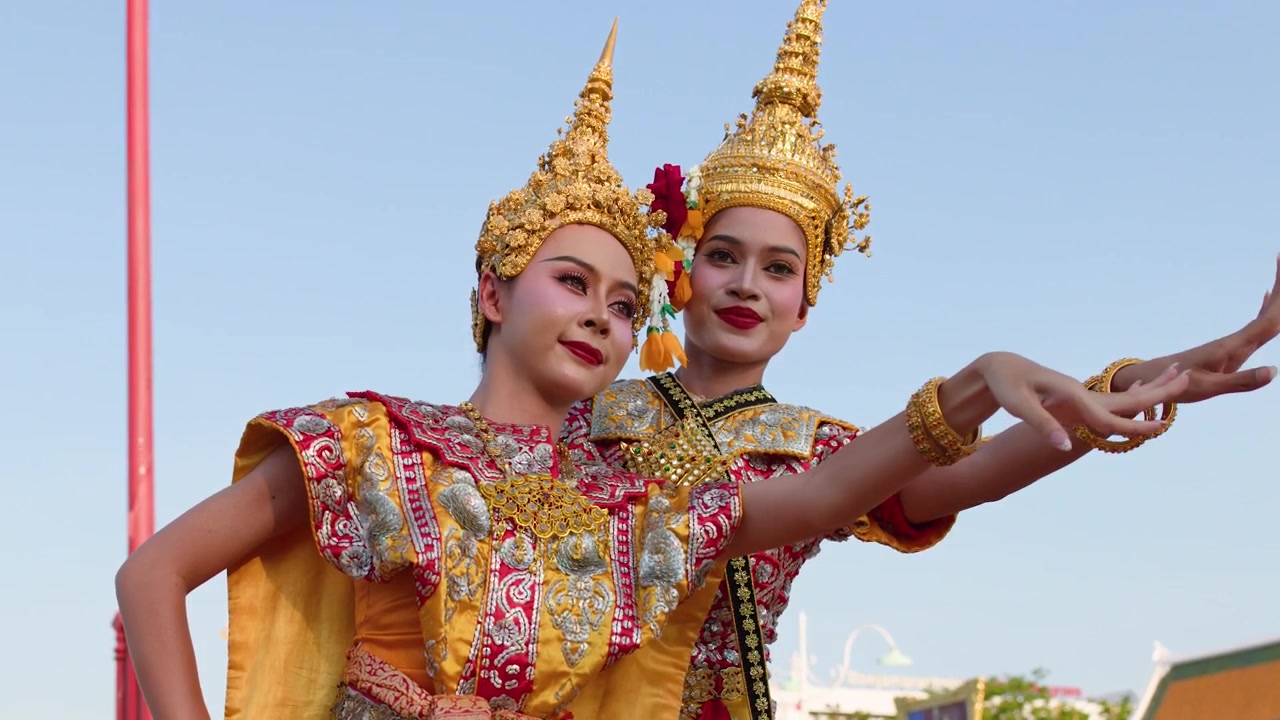 Due artiste in sontuosi costumi dorati eseguono la tradizionale danza Khon all'aperto a Bangkok