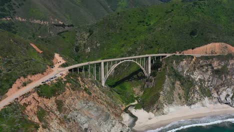 Weite-Luftaufnahme-Der-Bixby-Creek-Bridge-An-Einem-Sonnigen-Sommertag-In-Big-Sur,-Kalifornien-Mit-Dem-Weißen-Sandstrand-Darunter