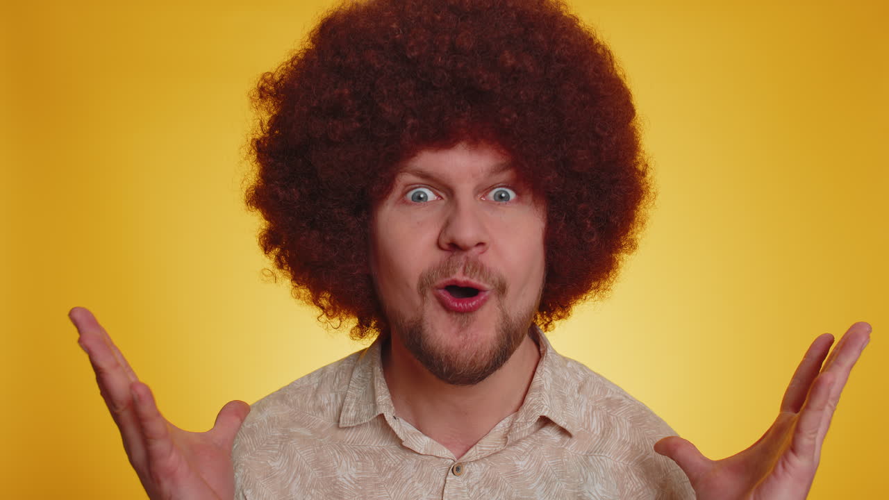 놀란 젊은 남자가 큰 눈으로 카메라를 쳐다보며 놀랐습니다. 갑작스러운 승리에 충격을 받았습니다.