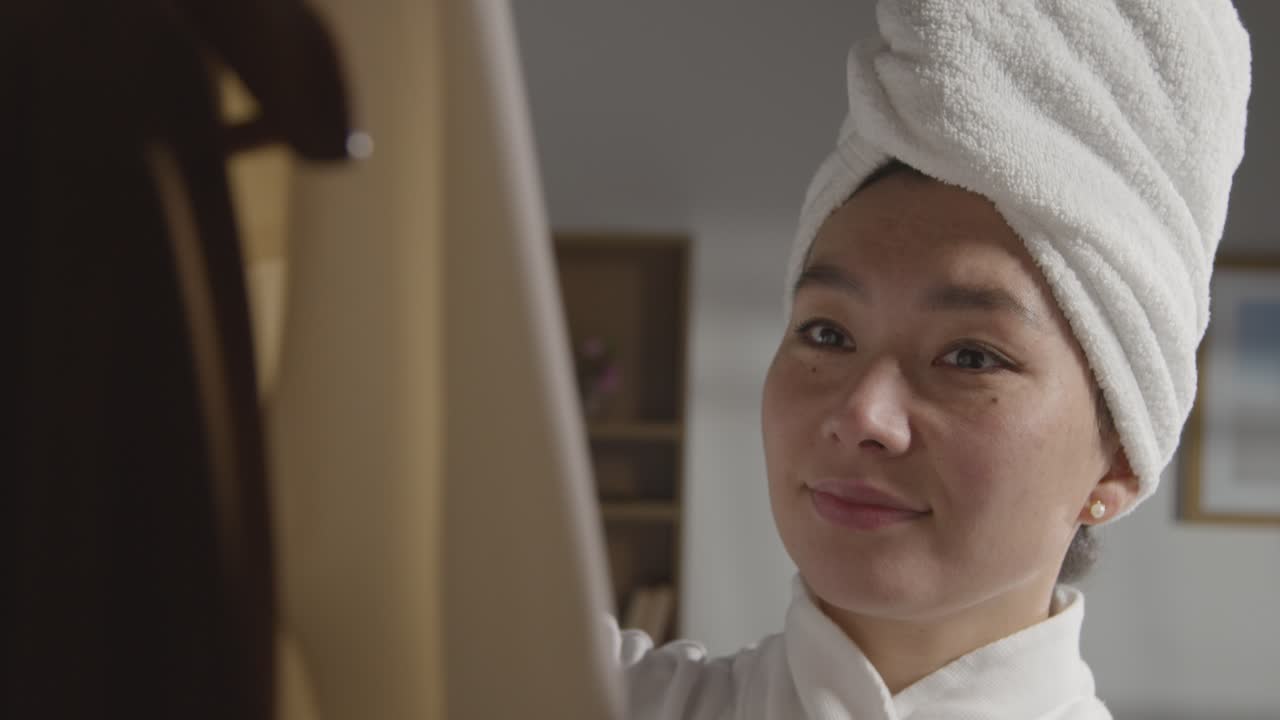 취직 면접을 위해 옷장에서 비즈니스 정장을 선택하는 샤워를 마치고 집에 있는 젊은 여성 2