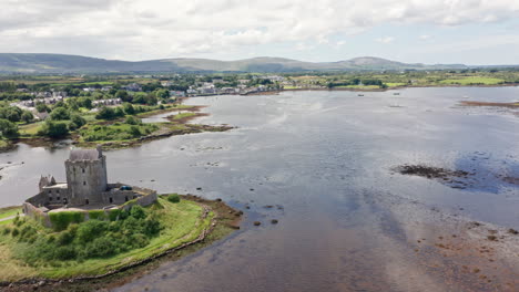 Toma-Aérea-Del-Histórico-Castillo-Dunguaire-Y-La-Bahía-De-Galway-En-El-Condado-De-Galway,-Irlanda