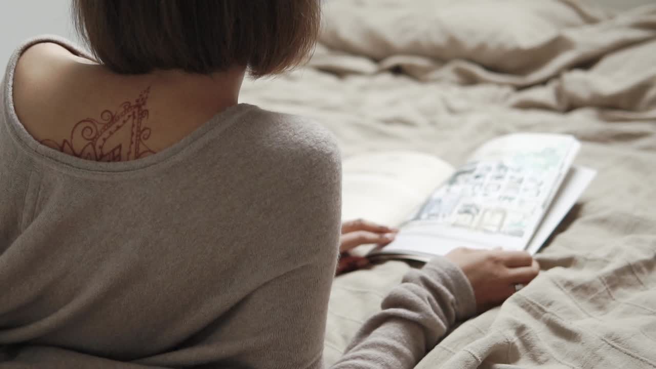 Donna che legge un libro a letto
