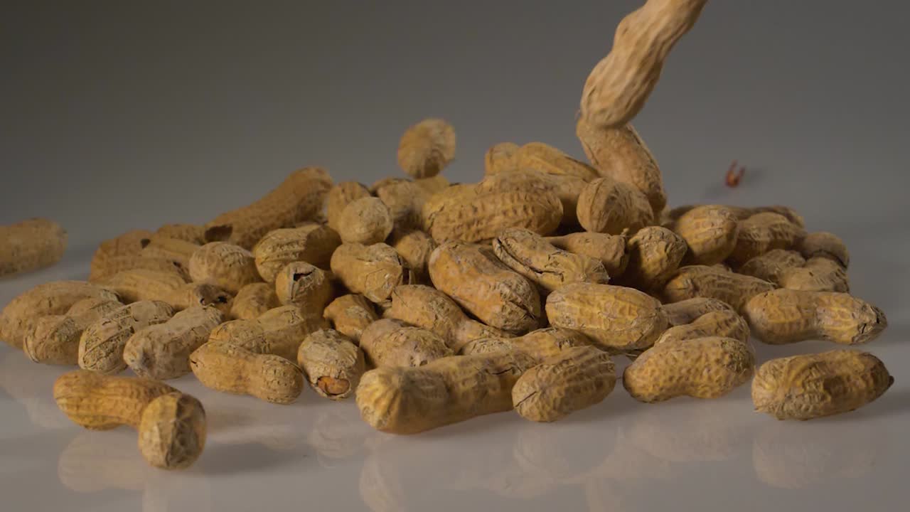 Peanuts in shells fall in slow motion