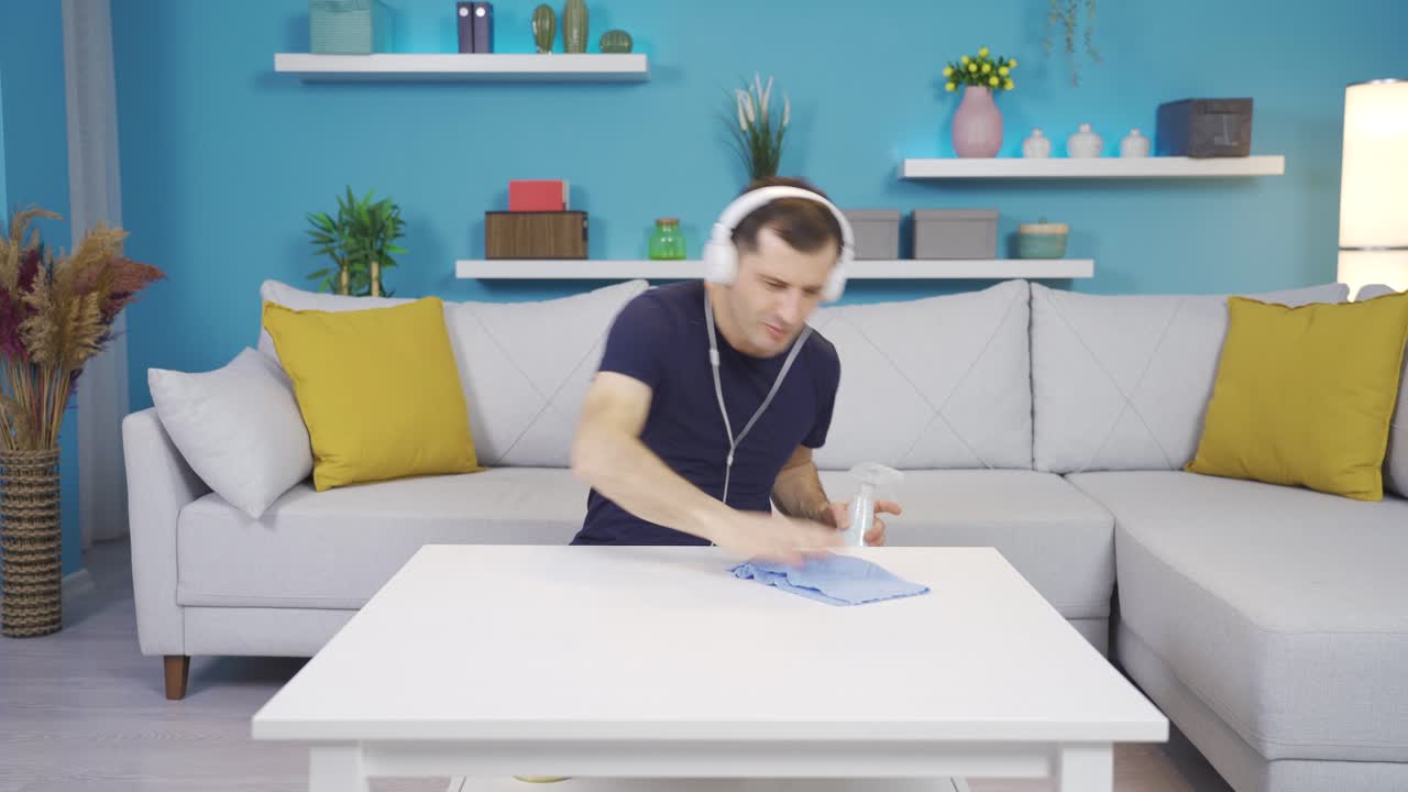 hombre de limpieza enérgico y de alto modo, limpiando el polvo. tipo gracioso.