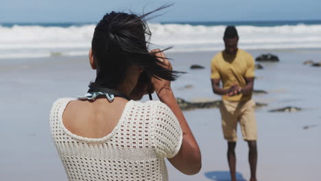 Afroamerikanische-Frau-Fotografiert-Ihren-Mann-Mit-Einer-Digitalkamera-Am-Strand