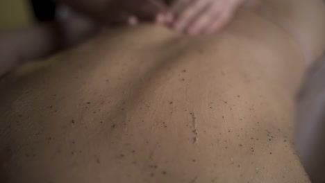 woman receiving a back massage with body scrub