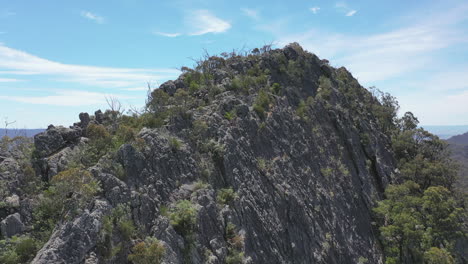 Massive-eroded-rock-outcrop-stands-tall-above-surrounding-green-valley