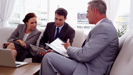 personas de negocios discutiendo juntos en un sofá