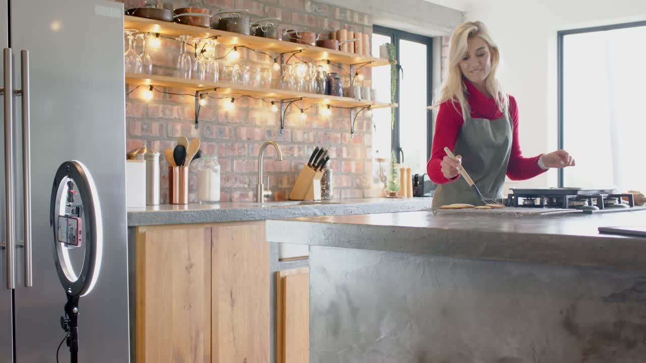 Grabbing spatula White woman stirring skillet at kitchen island tasting, showing dish, copy space