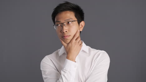 asian man thinking in front of the camera.