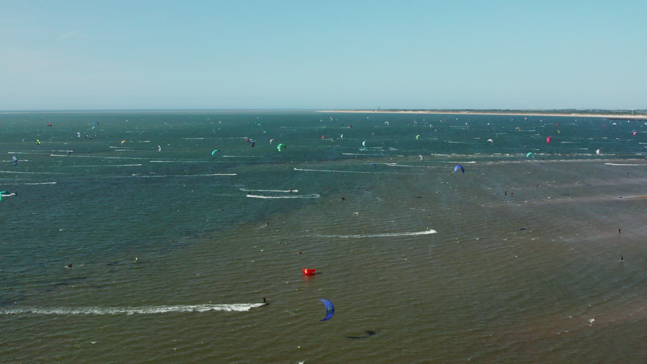 turistas haciendo kitesurf en el océano en brouwersdam, países bajos - panorámica aérea