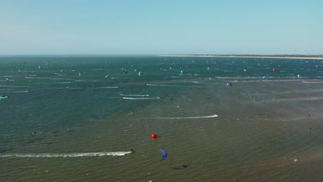 Turistas-Practicando-Kitesurf-En-El-Océano-En-Brouwersdam,-Países-Bajos---Panorámica-Aérea