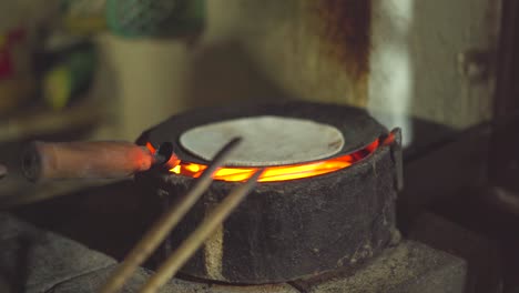 making chappati or indian bread on a frying pan inside kitchen of an indian dhaba or restaurant