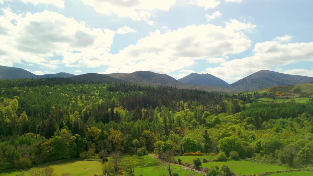 Wide aerial video of the Mourne Mountains and Slieve Donard in Newcastle, County Down in Northern Ireland, UK on a bright and sunny day. Filmed in 4K, 60fps and with Rec709 Color.
