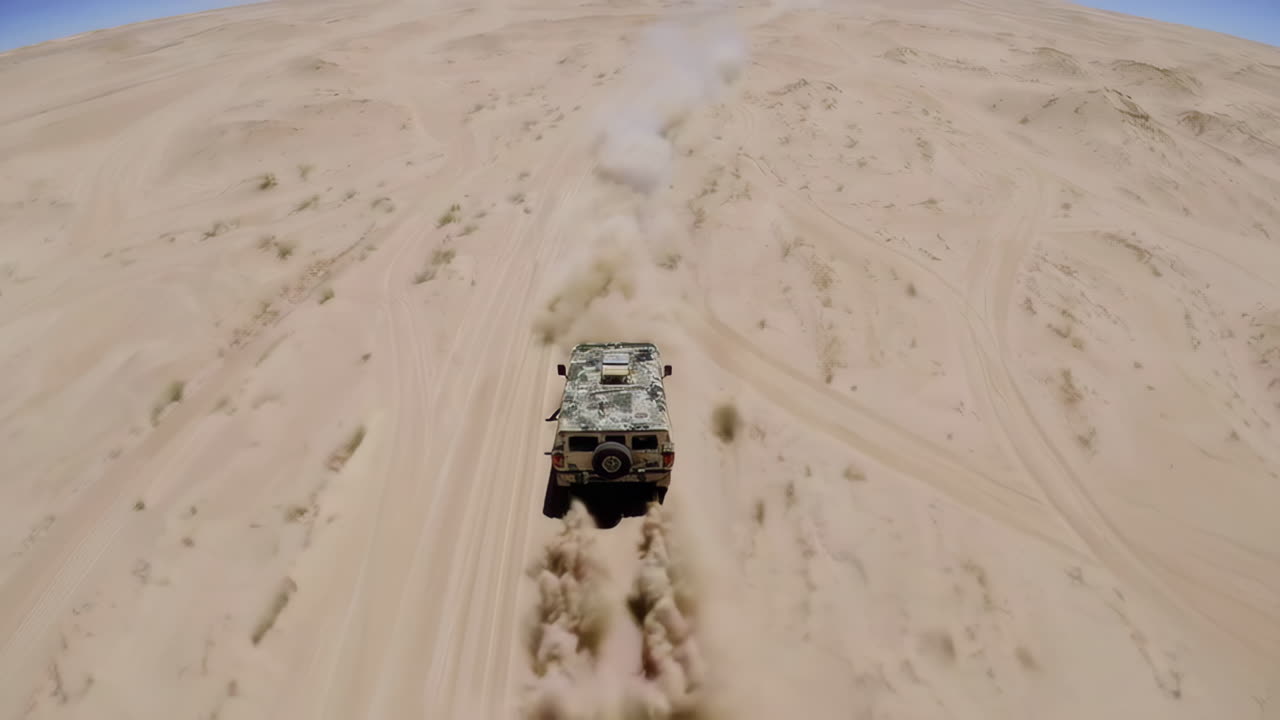 Military Vehicle Driving Through Sand Dunes