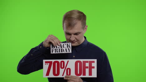 shocked amazed store client. man showing black friday and up to 70 percent off inscriptions signs