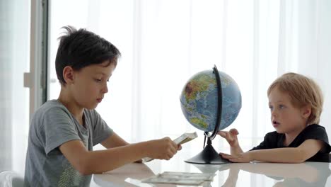 two caucasian boys spin counting money for travel