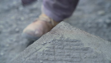 handheld shot of cancagua stone craftsman using a chisel to shape the edge of a stone slab in the city of ancud on the island of chiloe