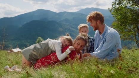 Glückliche-Familie,-Entspannendes-Gras-An-Sonnigen-Tagen.-Paar-Mit-Kindern-Liegt-Auf-Der-Grünen-Wiese.