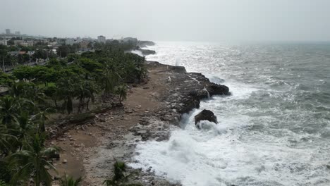 Aerial-drone-view-of-Santo-Domingo-rocky-coastline-relentlessly-assaulted-by-crashing-waves,-Dominican-Republic