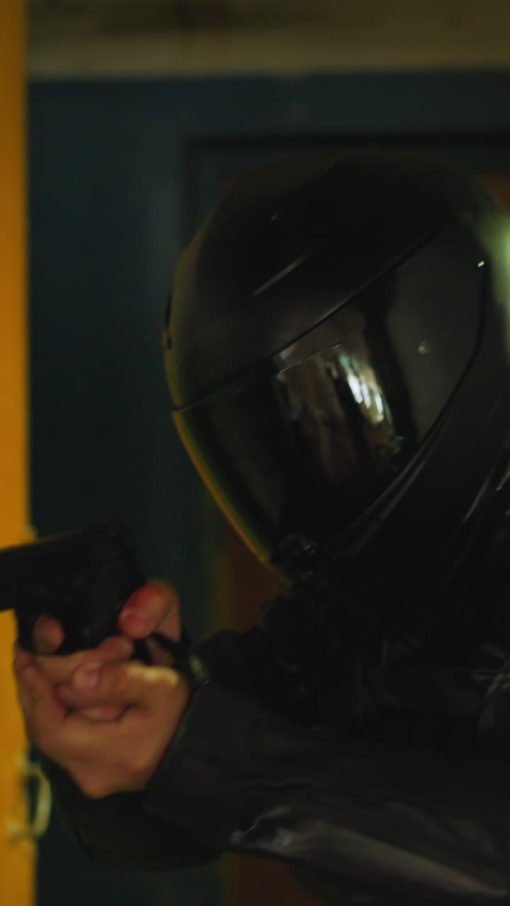 Trained army man in protective moto helmet with handgun walking carefully along demolished abandoned building room close view slow motion