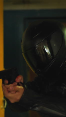 trained army man in protective moto helmet with handgun walking carefully along demolished abandoned building room close view slow motion