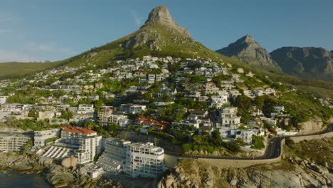 diapositiva y panorámica de apartamentos de lujo en una pendiente empinada en la costa del mar. montañas en el fondo. ciudad del cabo, sudáfrica