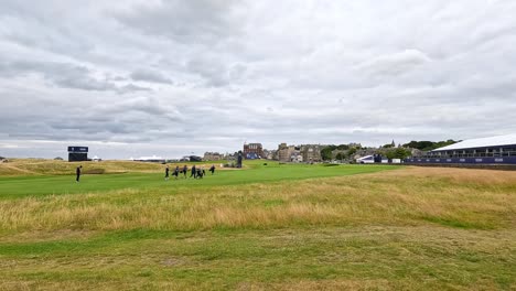 jugadores de golf caminando por el icónico campo de st. andrews