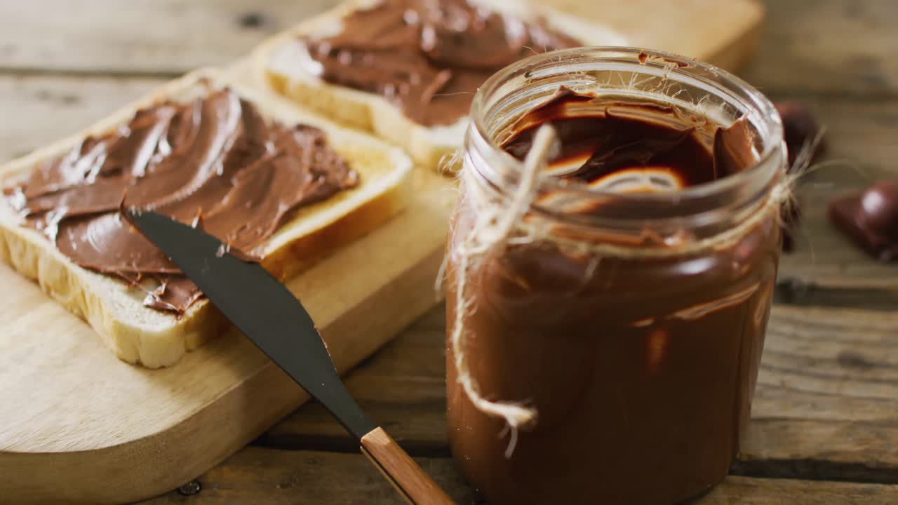 Video ravvicinato di toast con crema al cioccolato su sfondo di legno