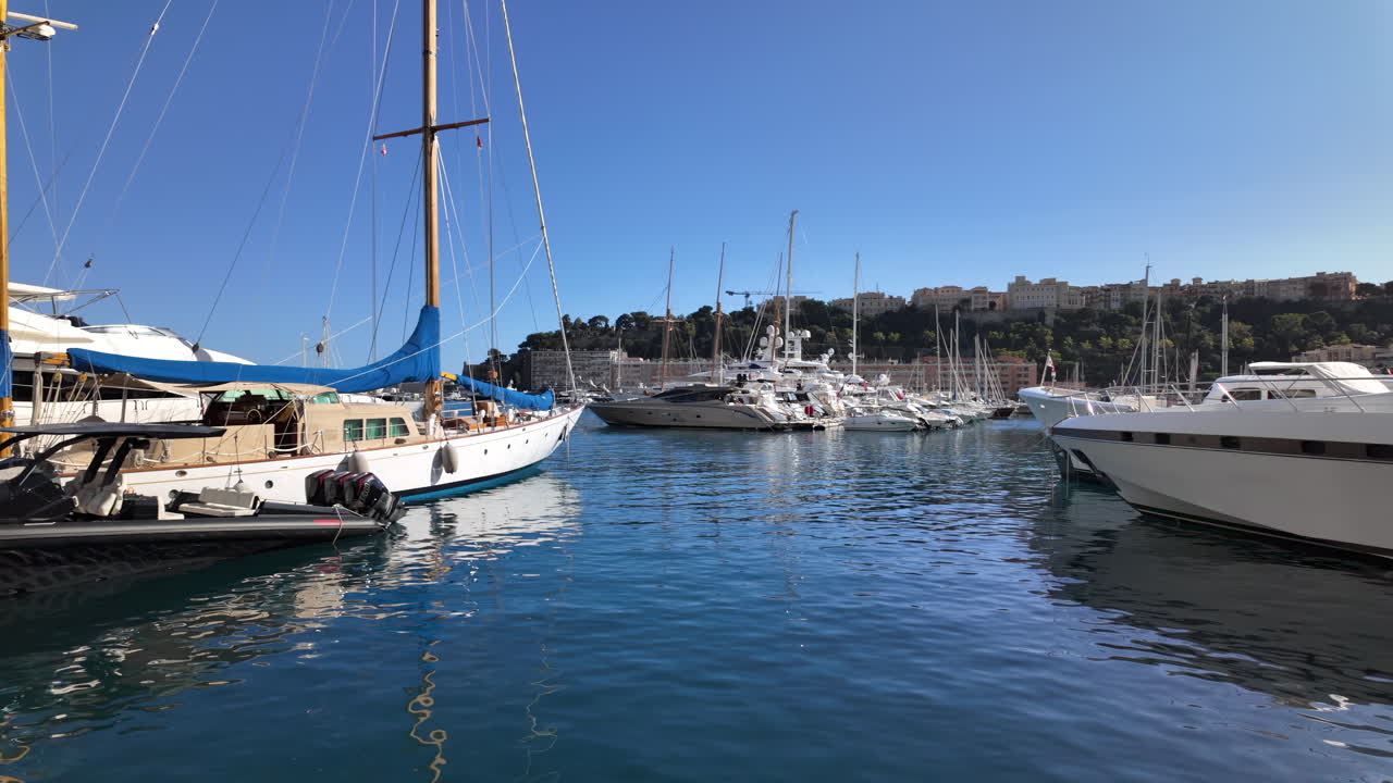 La Condamine, Monaco - July 18, 2025: Luxury yachts and sailing boats docked in calm blue waters at the marina