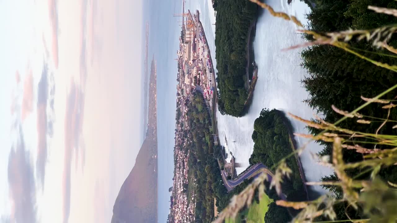 해가 지는 평온함: 플래그스타프에서 워렌포인트의 매혹적인 전망, 숲과 해안의 아름다움을  ⁇ 는 고속도로 | 수직 비디오