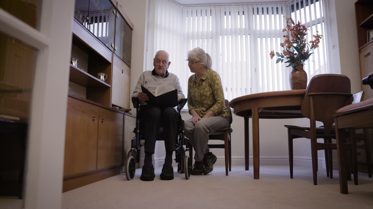 Elderly couple reading a book in their living room