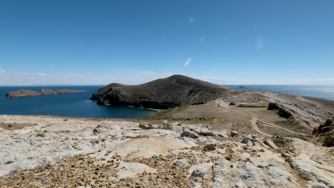 A sweeping pan shot showcases Cerro Tikani and the stunning tourist area on Isla del Sol, Copacabana, Bolivia. Serene beauty of this sacred island on Lake Titicaca, a prime destination for travel