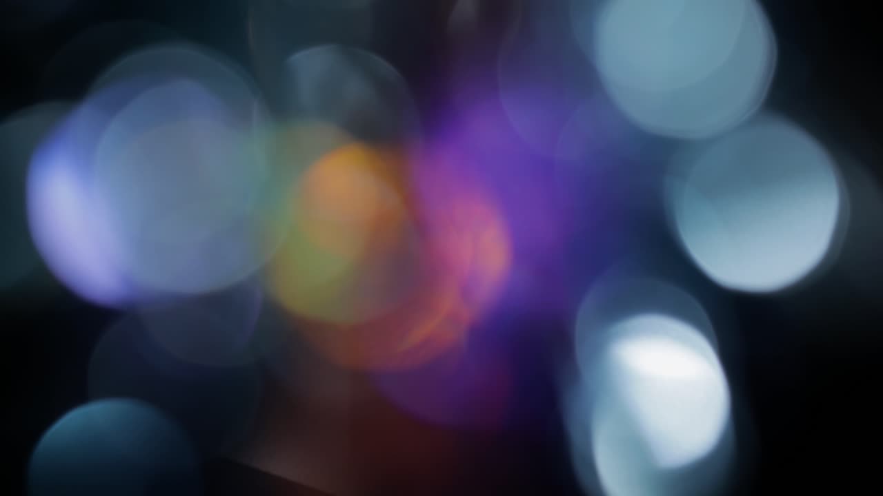 Fuoriuscite di luce multicolore, filmato 4K su sfondo nero, sovrapposizioni di bagliori, perdite di luce e scoppi di flare da obiettivo in studio