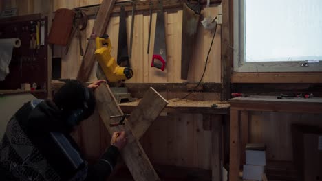 a man making a mark on a piece of lumber in indre fosen, trondelag county, norway - static shot